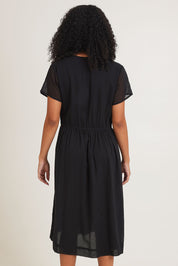 Model Ziara wearing size 10 of the Essentials Tie Waist Cotton Dress in colour Black (Black), from the back