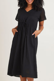 Model Ziara wearing size 10 of the Essentials Tie Waist Cotton Dress in colour Black (Black), from the front, cropped image