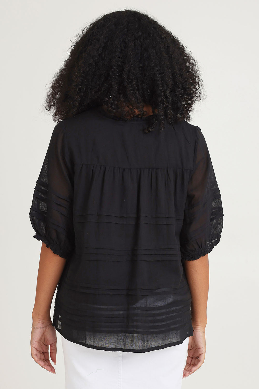 Model Ziara wearing size 10 of the Essentials Organic Cotton Pleated Top in colour Black (Black), from the back