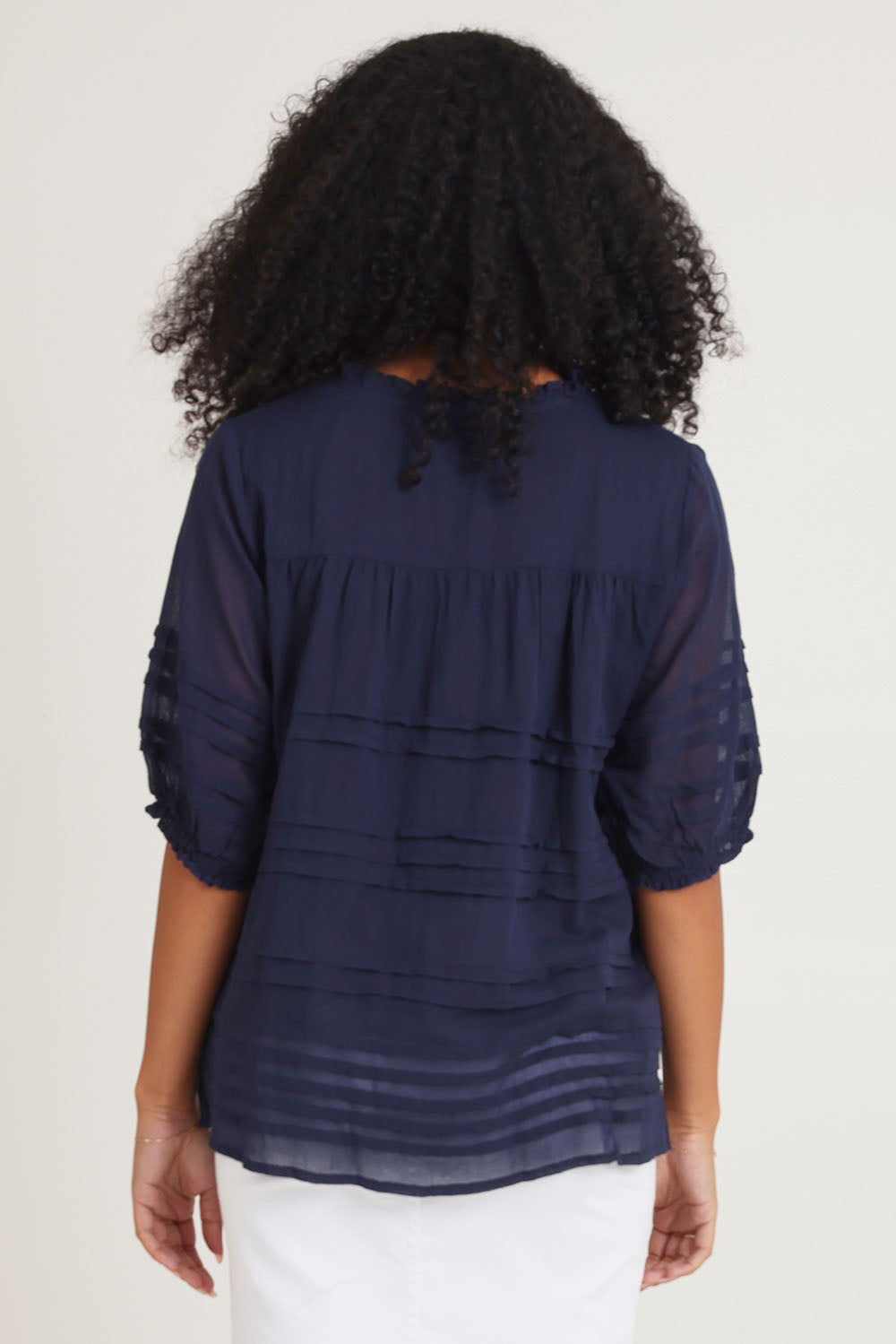 Model Ziara wearing size 10 of the Essentials Organic Cotton Pleated Top in colour Navy (Blue), from the back
