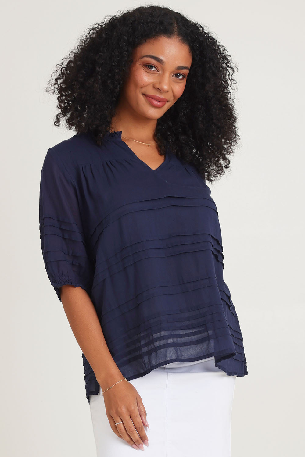 Model Ziara wearing size 10 of the Essentials Organic Cotton Pleated Top in colour Navy (Blue), from the front, cropped image