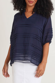 Model Ziara wearing size 10 of the Essentials Organic Cotton Pleated Top in colour Navy (Blue), from the front, cropped image
