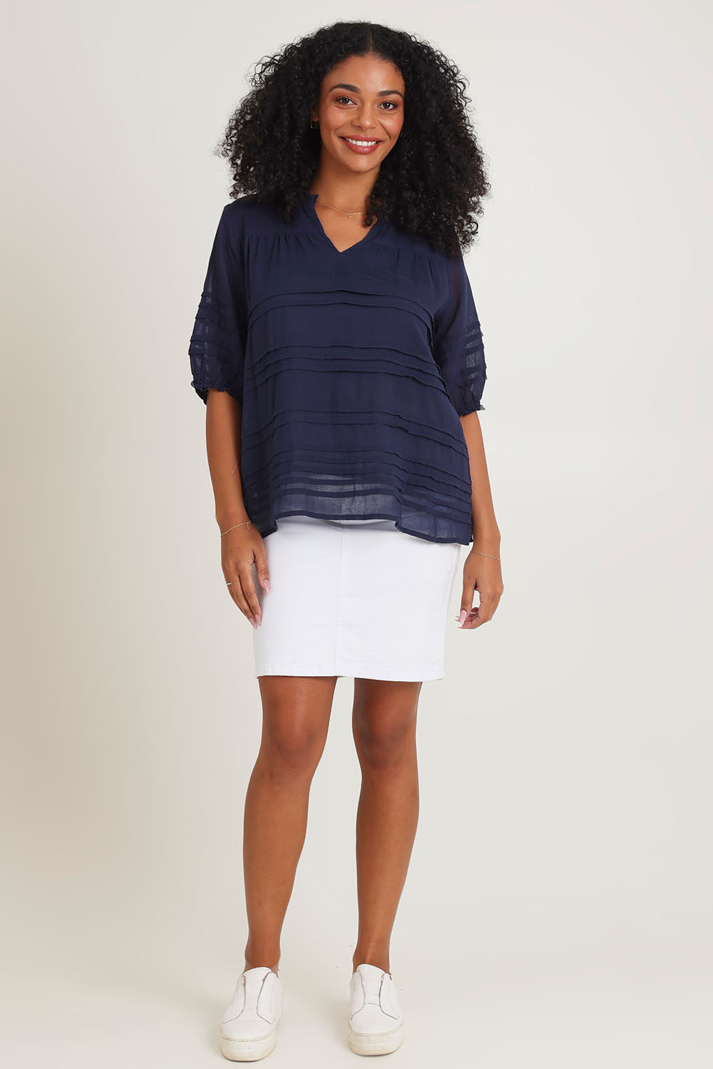 Model Ziara wearing size 10 of the Essentials Organic Cotton Pleated Top in colour Navy (Blue), from the front, showing the whole outfit