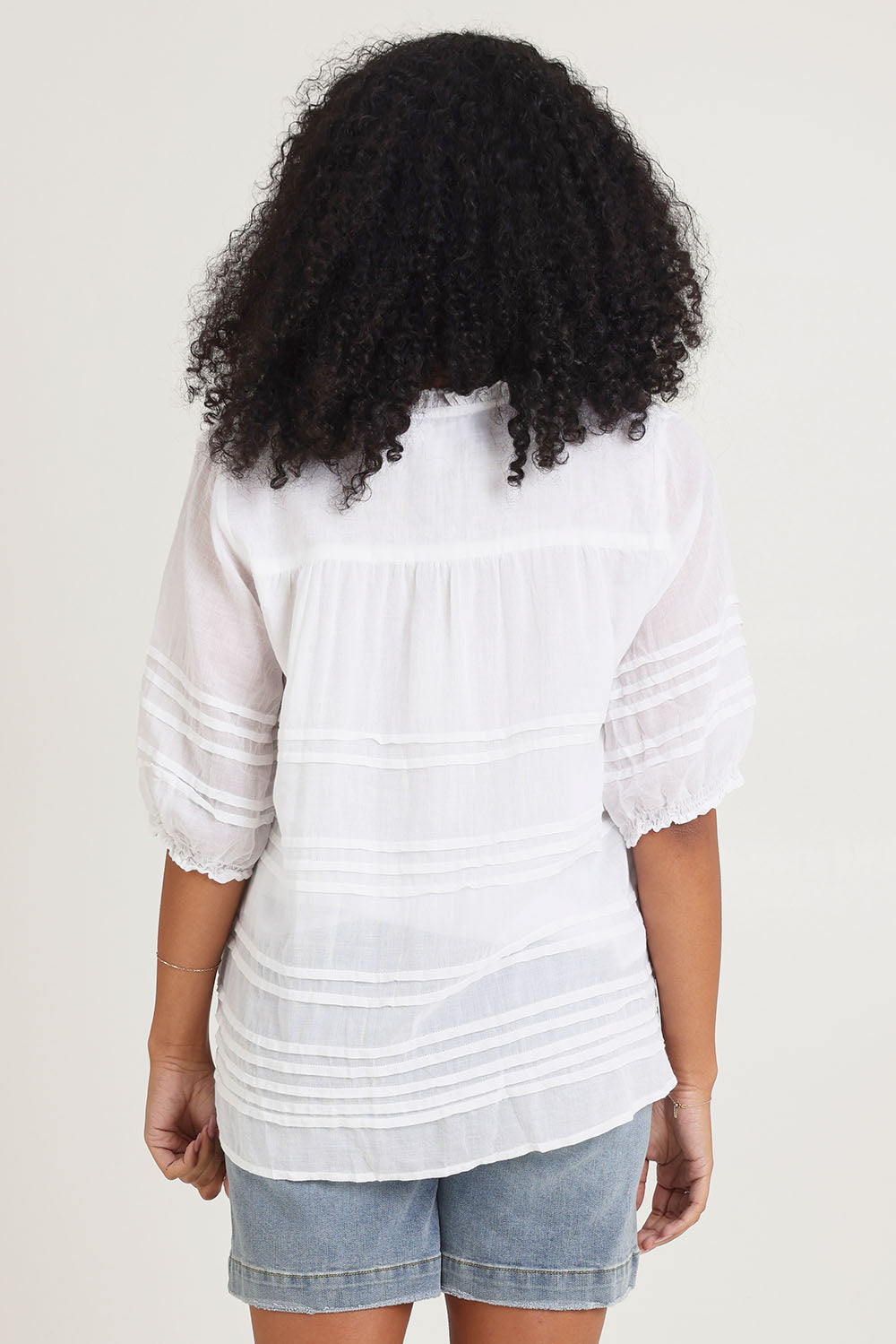 Model Ziara wearing size 10 of the Essentials Organic Cotton Pleated Top in colour White (White), from the back