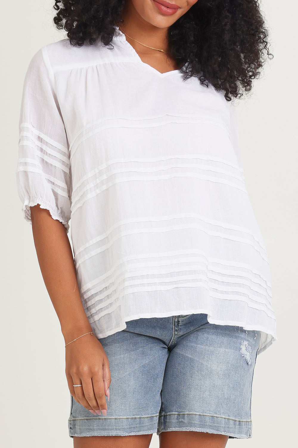 Model Ziara wearing size 10 of the Essentials Organic Cotton Pleated Top in colour White (White), from the front, cropped image