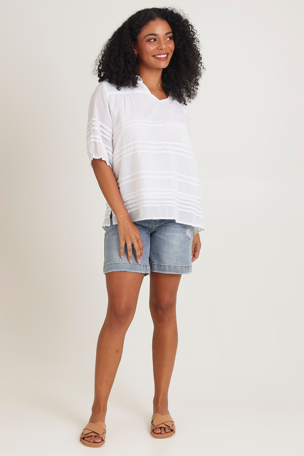 Model Ziara wearing size 10 of the Essentials Organic Cotton Pleated Top in colour White (White), from the front, showing the whole outfit