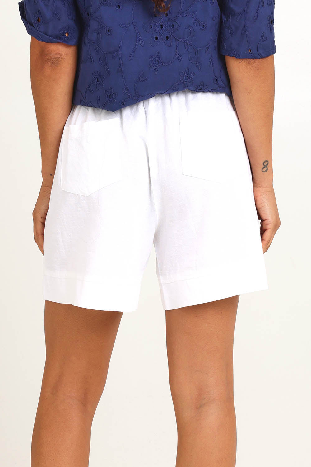 Model Pamelar wearing size 10 of the Essentials Linen Blend Shorts - White in colour White, from the back