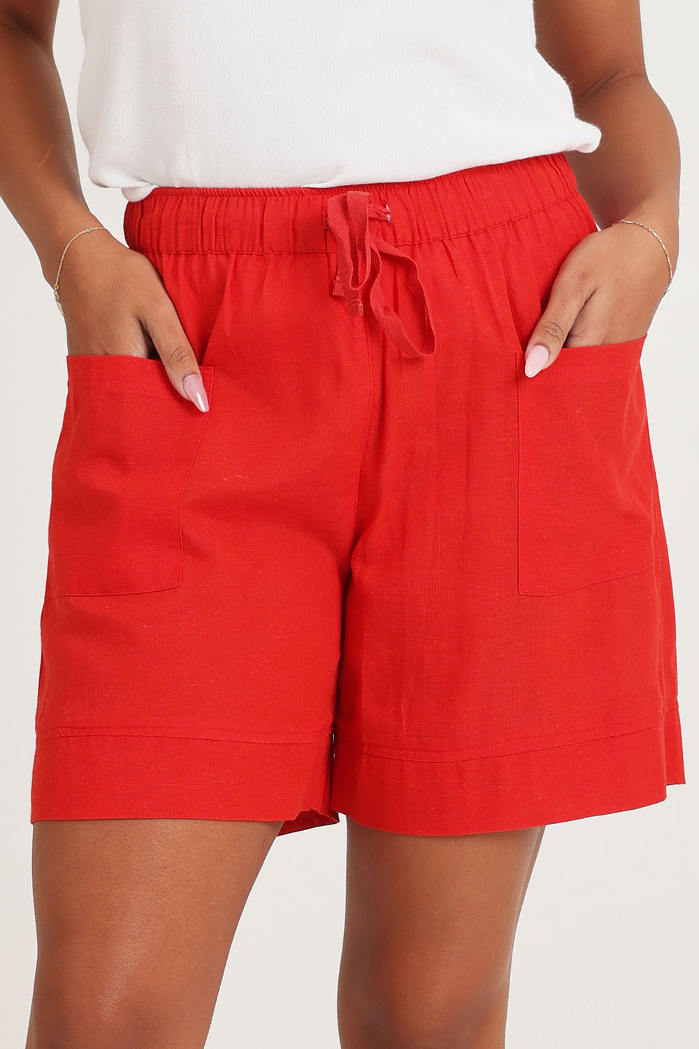 Model Ziara wearing size 10 of the Essentials Linen Blend Shorts in colour Red (Red), from the front, cropped image