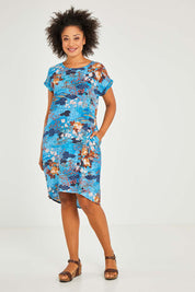 Model Olivia wearing size 10 of the Parga Organic Cotton Simple Cut Dress in colour Print (Blue), from the front, showing the whole outfit