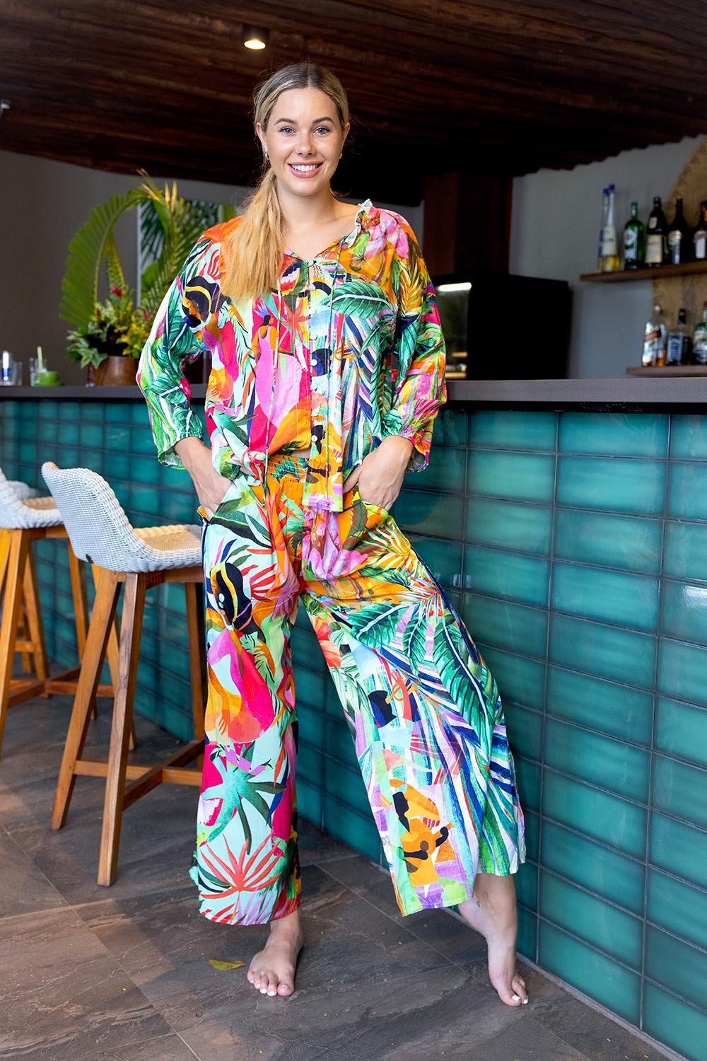 A model wearing the Rio Shirred Waist Pant in colour Rio (Green), from the front, showing the whole outfit