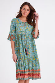 Model Madeline wearing size 10 of the Chania 3/4 Sleeve Layers Dress in colour Print (Green), from the front, cropped image