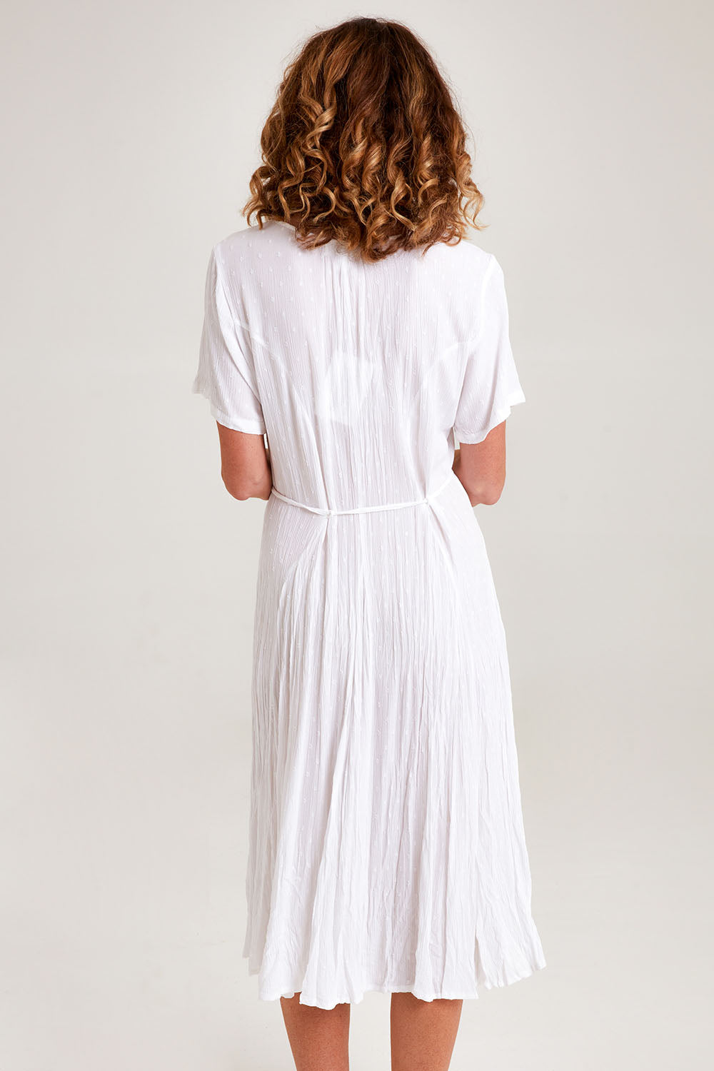 Model Emma wearing size 10 of the Essentials Godet Short Sleeve Dress in colour White (White), from the back
