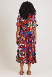Model Ziara wearing size 10 of the Salvador Short Sleeve Godet Dress in colour Print, from the back
