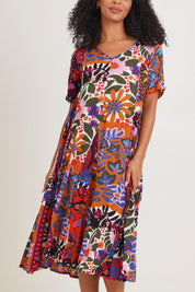 Model Ziara wearing size 10 of the Salvador Short Sleeve Godet Dress in colour Print, from the front, cropped image
