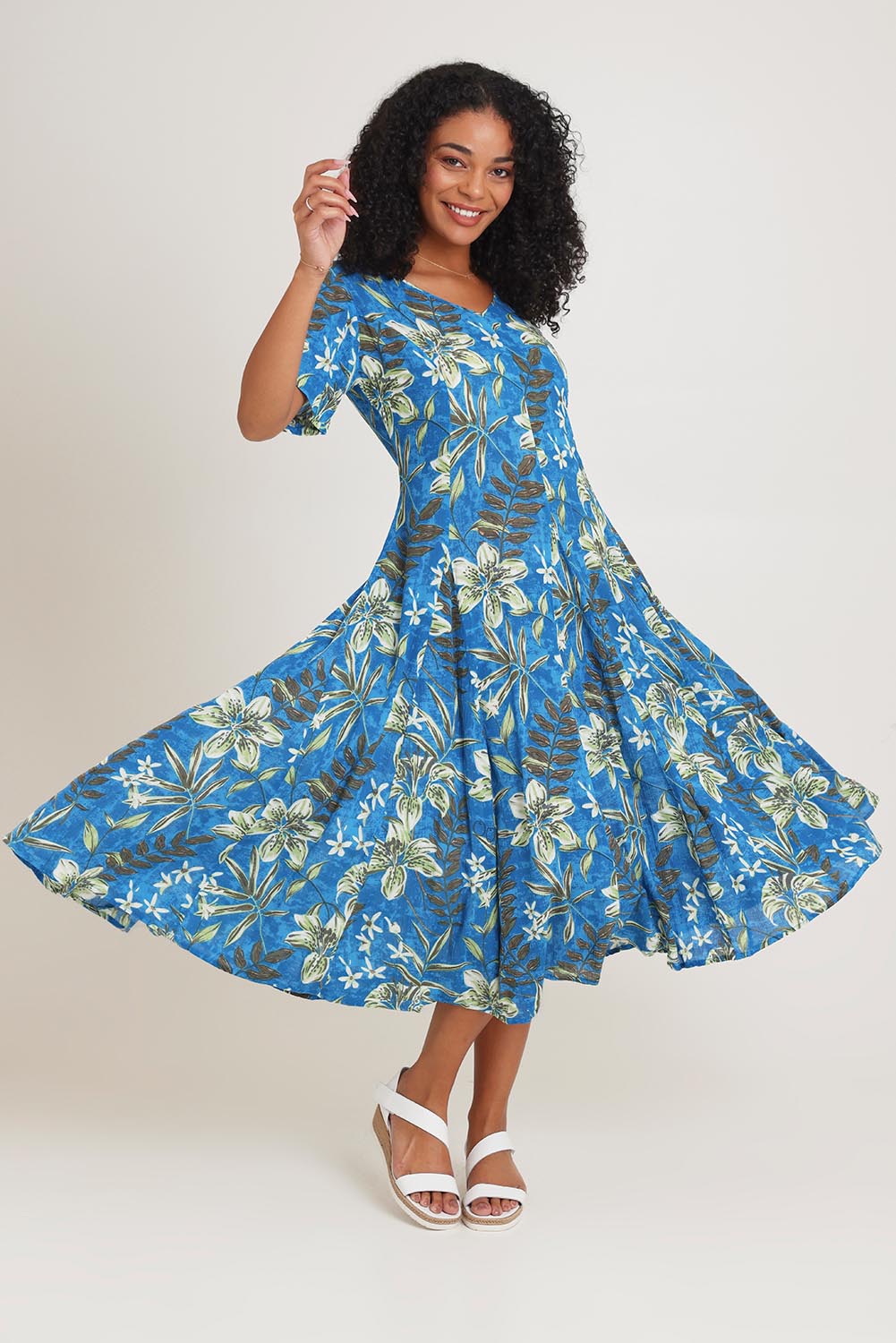 Model Ziara wearing size 10 of the Short Sleeve Godet Dress in colour Miramar, from the front, showing the whole outfit