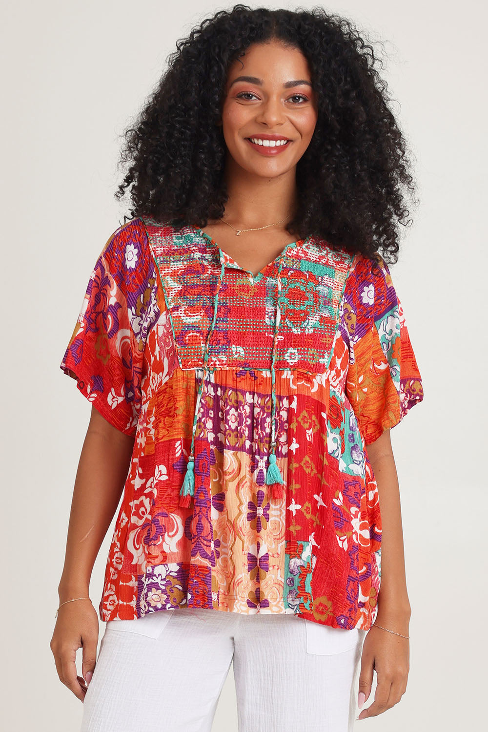 Model Ziara wearing size 10 of the Bib Top in colour Araya, from the front, cropped image