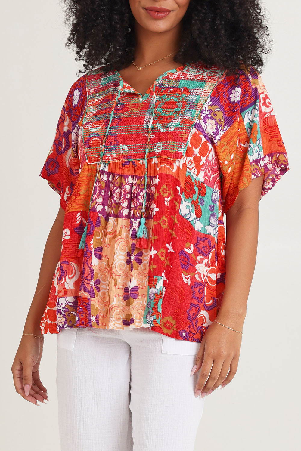 Model Ziara wearing size 10 of the Bib Top in colour Araya, from the front, cropped image