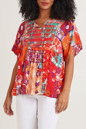 Model Ziara wearing size 10 of the Bib Top in colour Araya, from the front, cropped image