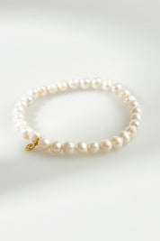 A model wearing the Thick Healing Gem Bracelet in colour Prosperity (White), from the front, showing the whole outfit