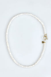 A model wearing the Pearl Fob Necklace in colour Pearl (White), from the front, showing the whole outfit