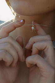 A model wearing the Dreamweaver Necklace in colour Makeawish (Metallics), from the front, showing the whole outfit