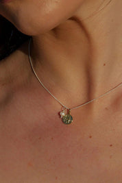A model wearing the Dreamweaver Necklace in colour Safetravel (Metallics), from the front, showing the whole outfit