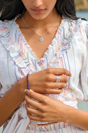 A model wearing the Healing Gem Bracelet in colour Creativity (Blue), from the front, showing the whole outfit