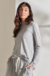 A model wearing the Organic Cotton Knit Long Sleeve Tee in colour Grey (Grey), from the front, showing the whole outfit