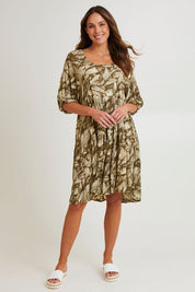 Model Madeline wearing size S of the Crinkle Dress in colour Leaves (Green), from the front, showing the whole outfit