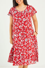 Model Terri-Leigh wearing size L of the Cotton Cap Sleeve Dress in colour Redprint (Red), from the front, cropped image