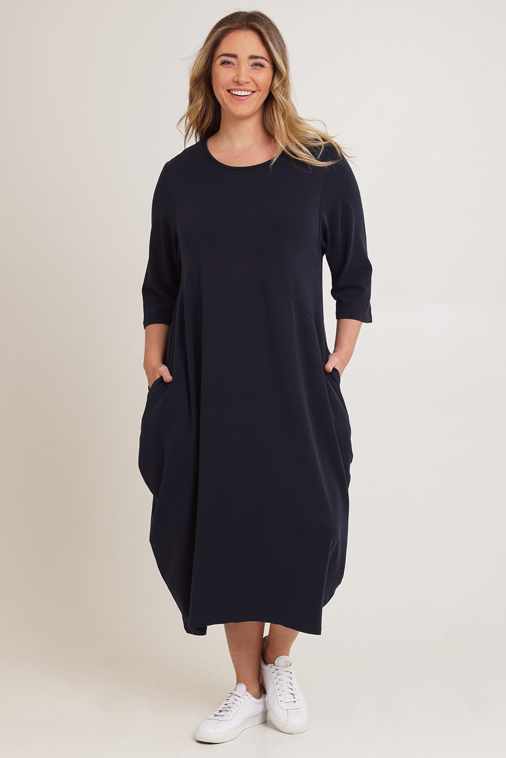 Model Chanel wearing the Alviva Lounge Dress in colour Navy (Blue), from the front, showing the whole outfit
