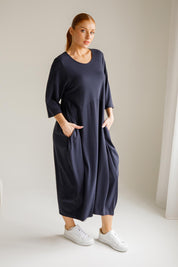 A model wearing the Alviva Lounge Dress in colour Navy (Blue), from the front, showing the whole outfit