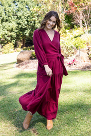 A model wearing the L/S Ruffle Wrap Dress in colour Mahogany (Pink), from the front, showing the whole outfit