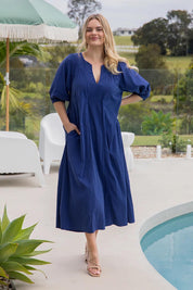 A model wearing the Novella Tencel Blend Dress in colour Pacific (Blue), from the front, showing the whole outfit