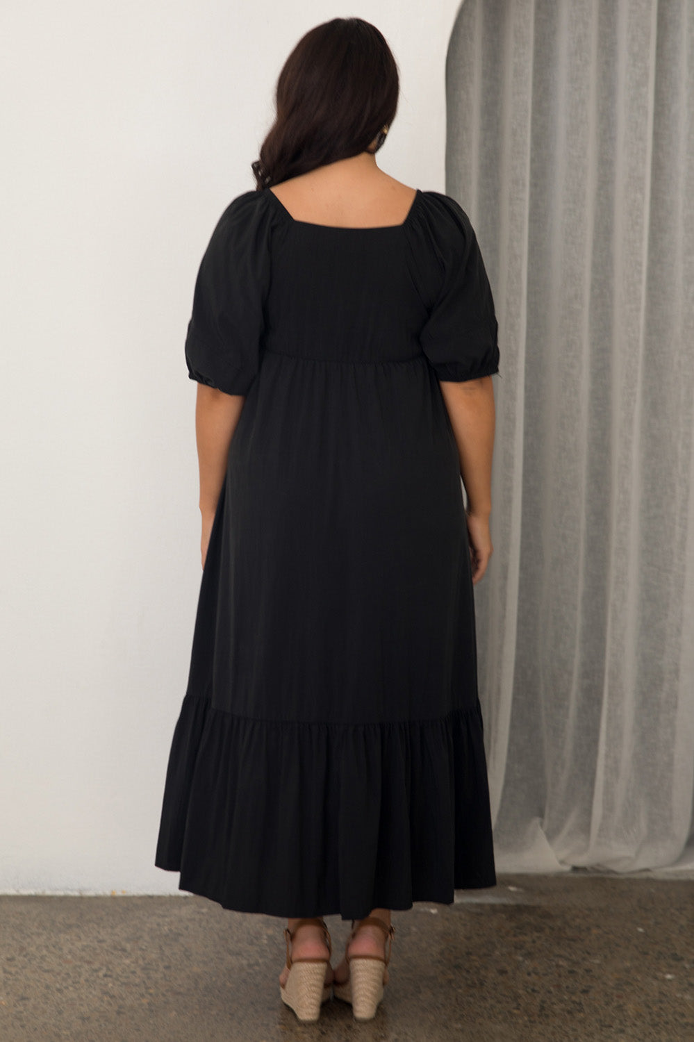 A model wearing the Austin Midi Tencel Blend Dress in colour Black (Black), from the back