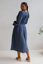 A model wearing the Jade Tencel Dress in colour Storm (Blue), from the back