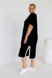 A model wearing the Gigi Lounge Dress in colour Black (Black), from the back