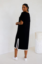 A model wearing the Gigi Lounge Dress in colour Black (Black), from the back