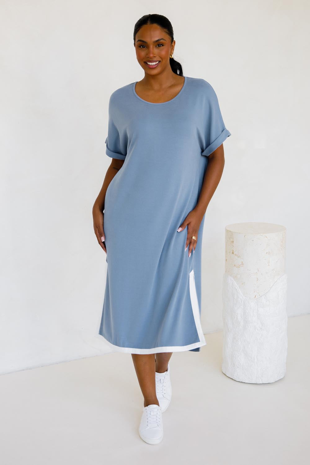 A model wearing the Gigi Lounge Dress in colour Dusk (Blue), from the front, showing the whole outfit