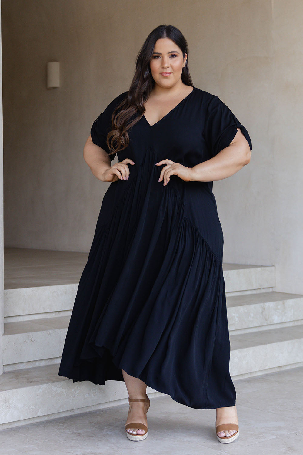 A model wearing the Short Sleeve Peak Maxi Dress in colour Black (Black), from the front, showing the whole outfit