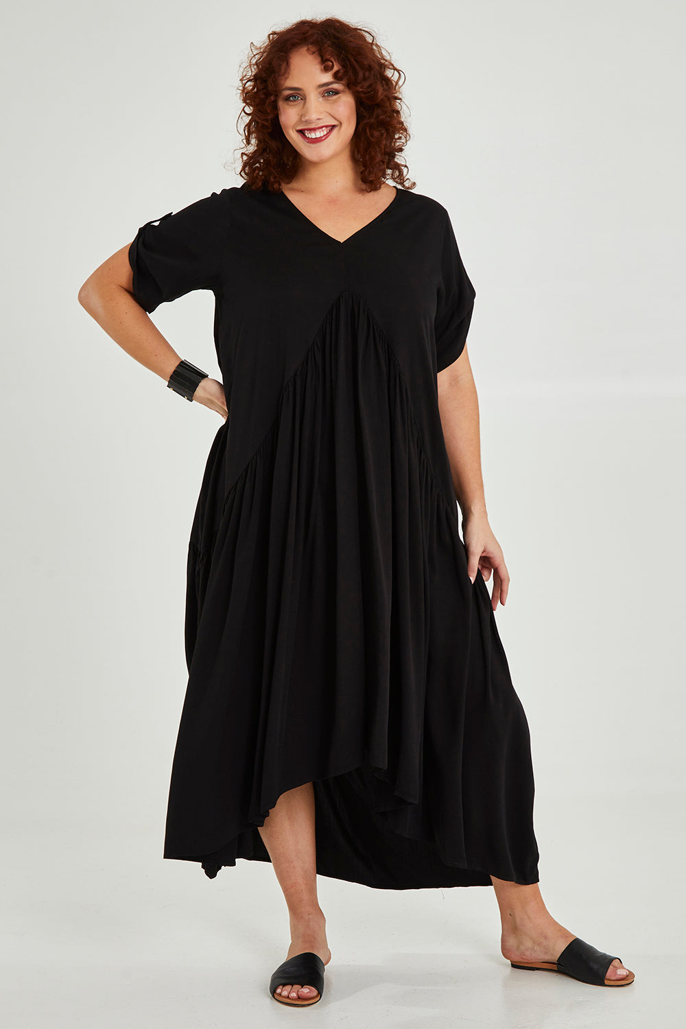 Model Maddy wearing the Short Sleeve Peak Maxi Dress in colour Black (Black), from the front, showing the whole outfit