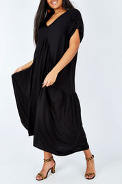 Model Shanaya wearing the Short Sleeve Peak Maxi Dress in colour Black (Black), from the front, cropped image