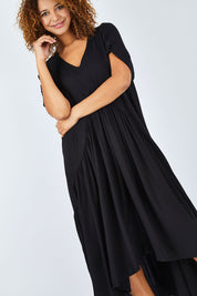 Model Summer wearing the Short Sleeve Peak Maxi Dress in colour Black (Black), from the front, cropped image
