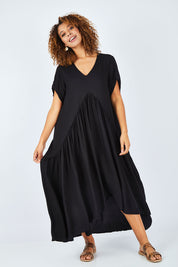 Model Summer wearing the Short Sleeve Peak Maxi Dress in colour Black (Black), from the front, showing the whole outfit