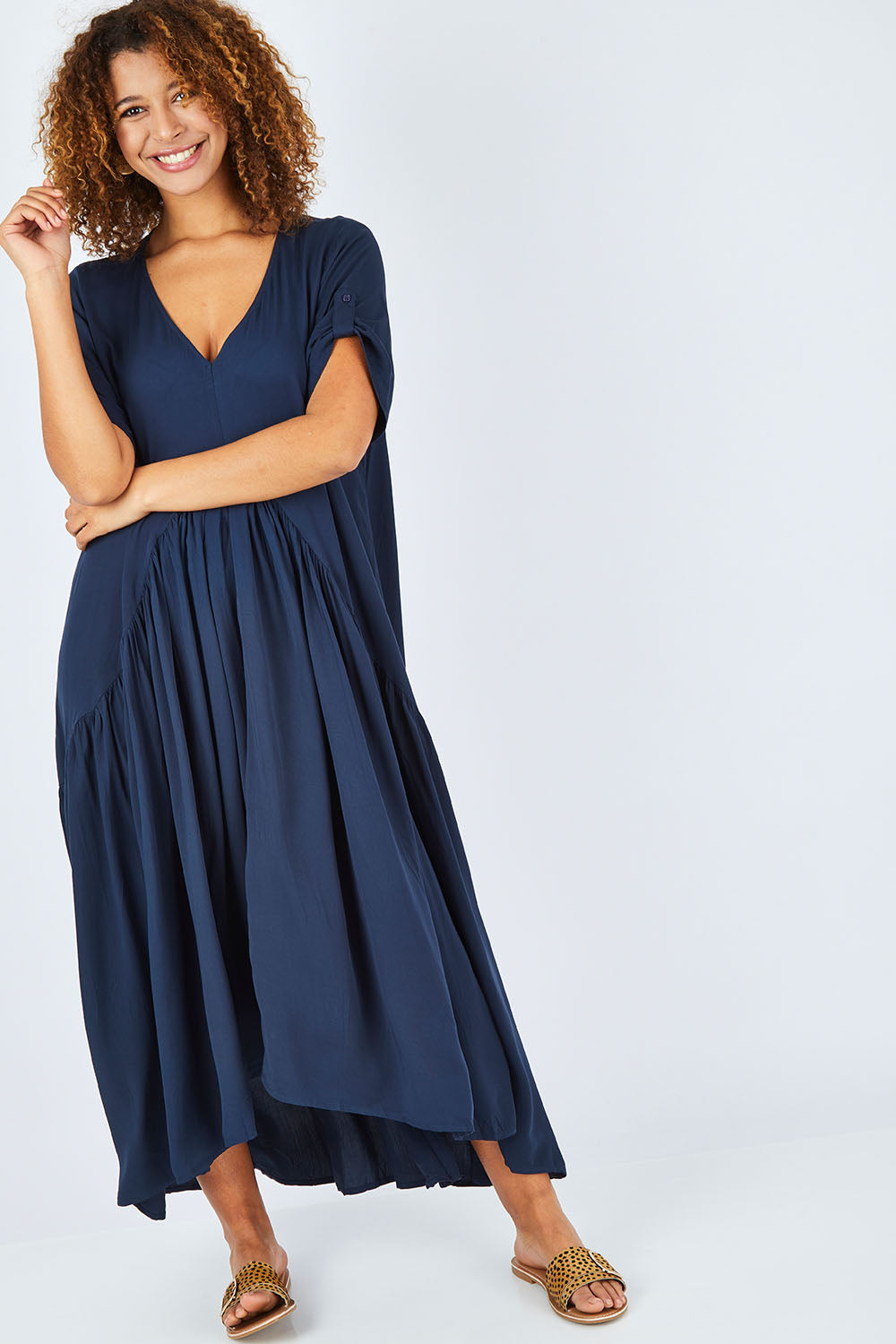 Model Summer wearing the Short Sleeve Peak Maxi Dress in colour Navy (Blue), from the front, showing the whole outfit
