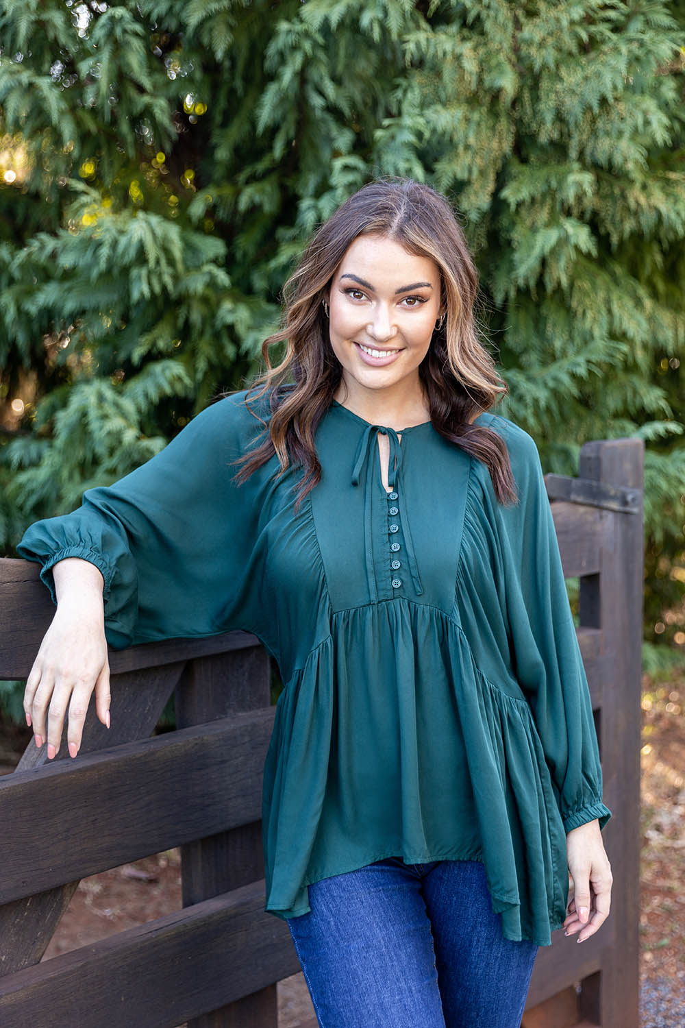 A model wearing the Charlie Top in colour Peacock (Green), from the front, showing the whole outfit