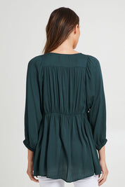 Model Madeline wearing size S of the Charlie Top in colour Peacock (Green), from the back