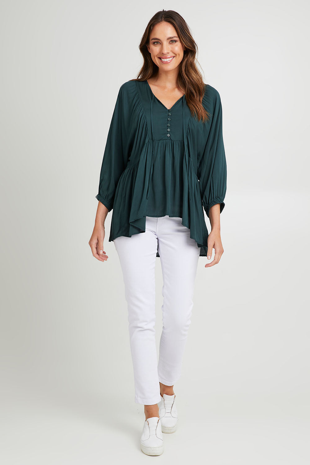 Model Madeline wearing size S of the Charlie Top in colour Peacock (Green), from the front, showing the whole outfit
