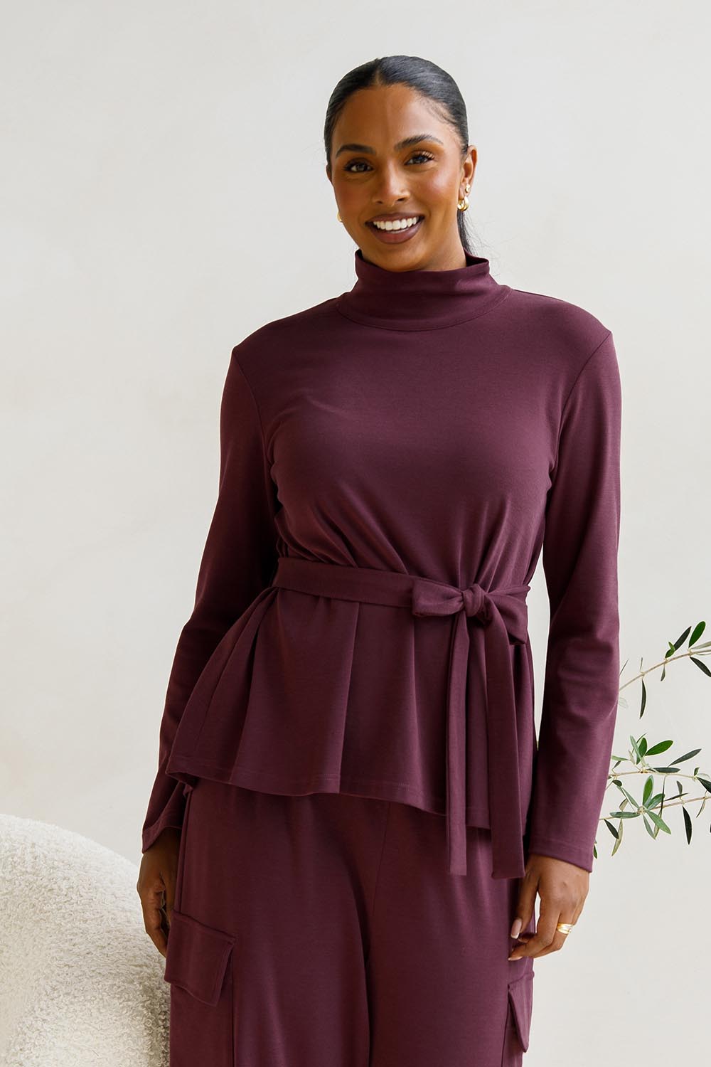 A model wearing the Jazmine Cotton Blend Top in colour Plum (Red), from the front, cropped image