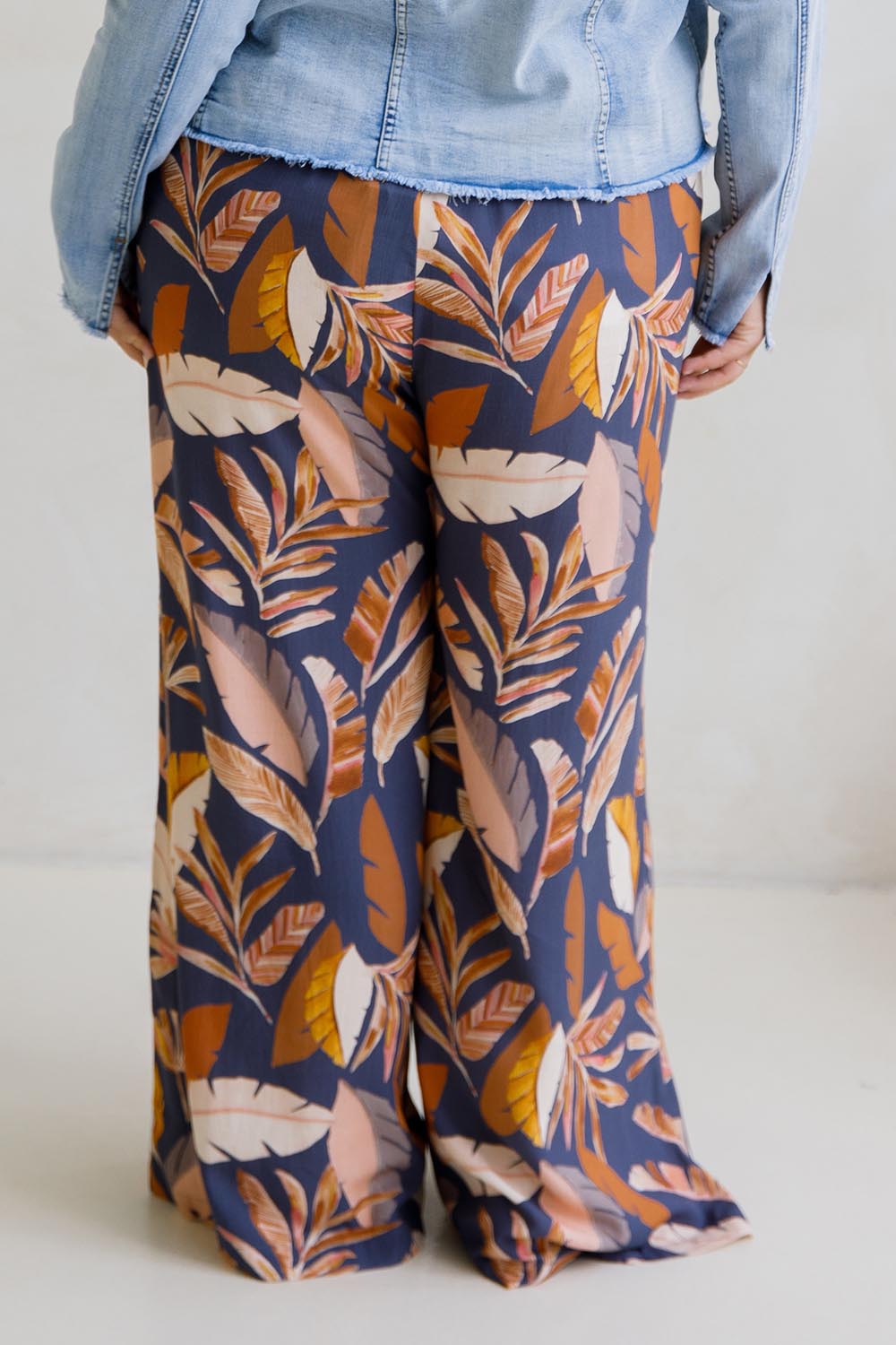 A model wearing the Aspen Pants in colour Darkpalme, from the back